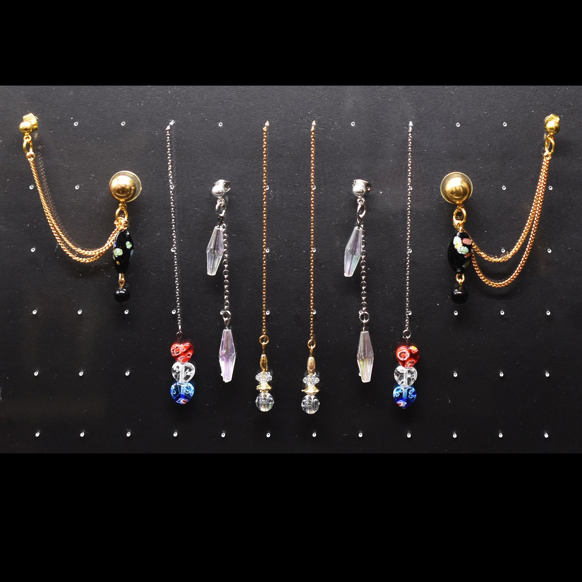 Several pairs of earrings with chain accents
