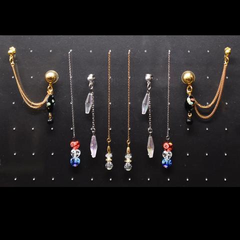 Several pairs of earrings with chain accents